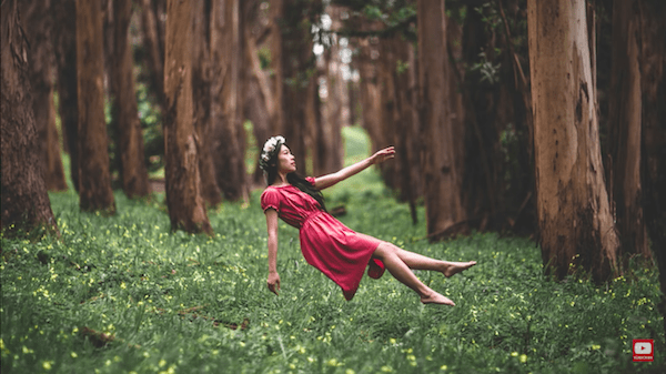 Levitating girl with pink dress in the forest 